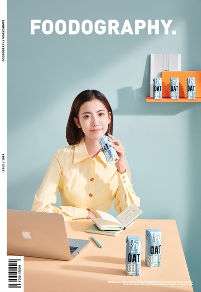 A high-quality lifestyle shot featuring a woman drinking oat milk in a clean, bright, professional workspace.