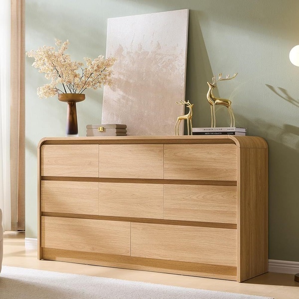 A high-quality product shot of a wooden dresser styled in a minimalist, warm-toned studio environment.