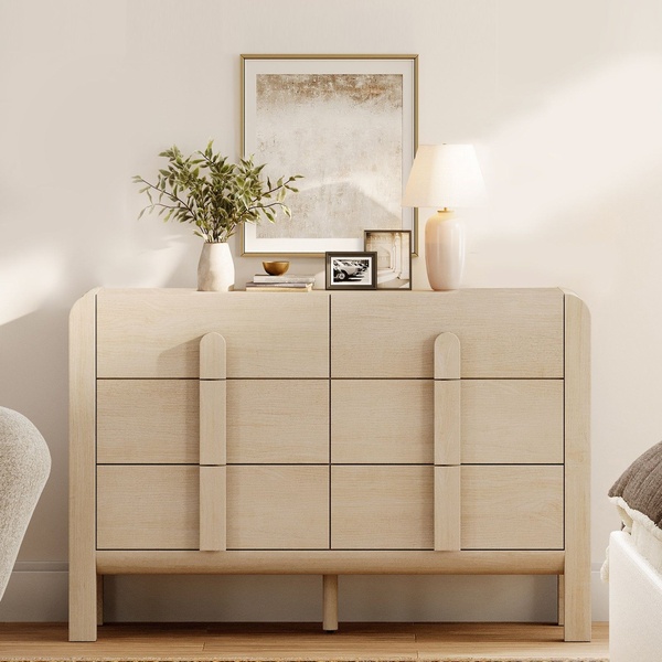 A high-quality, aspirational product shot of a wooden dresser in a neutral-toned room, emphasizing clean lines and sophisticated home styling.