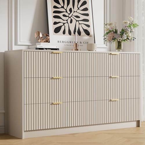 A high-quality studio shot of a light-colored, fluted-texture dresser styled with modern decor and neutral wall accents.