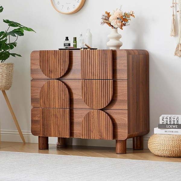 A high-quality studio shot of a textured wood chest of drawers, styled in a warm, modern, and uncluttered home environment.