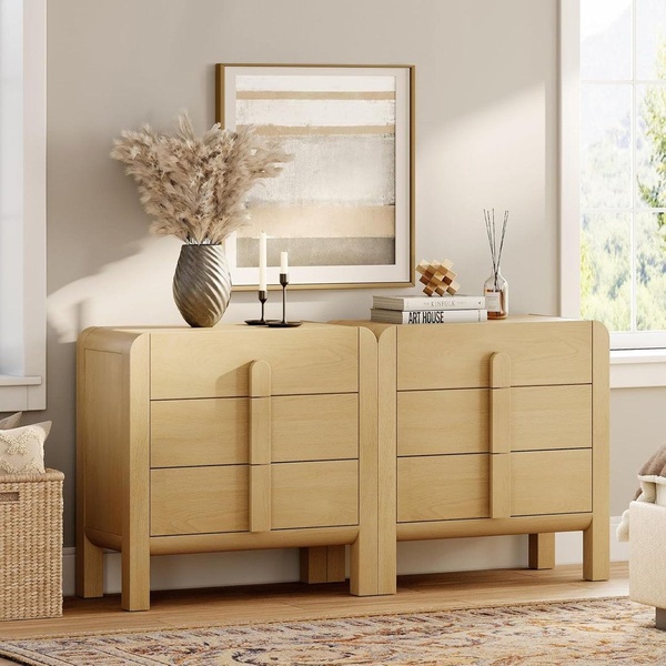 A clean, high-end studio shot of two matching wooden dressers styled with minimal, neutral decor elements.