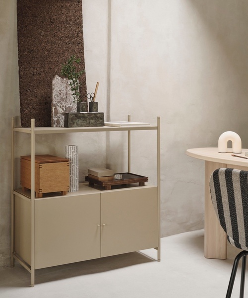 A high-end, lifestyle-focused image showcasing a storage cabinet styled with curated home decor in a neutral-toned, sunlit interior.