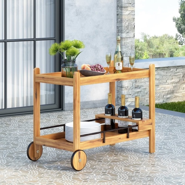 A high-end, staged product hero shot featuring a wooden outdoor serving cart styled with wine, glassware, and fresh decor on a patio.