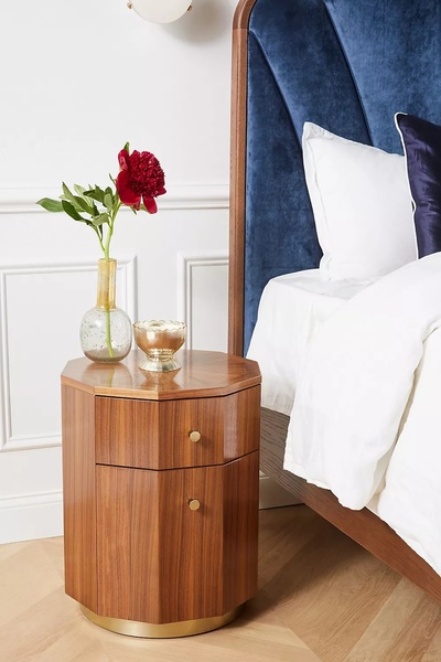 A high-end product hero shot of a wooden octagonal nightstand, styled with a fresh peony to emphasize a luxury lifestyle.