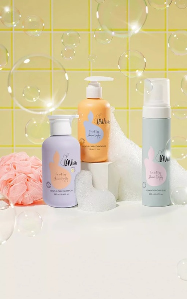A clean, studio-lit display of shampoo, conditioner, and shower gel surrounded by floating soap bubbles to emphasize a fun and gentle cleansing experience.
