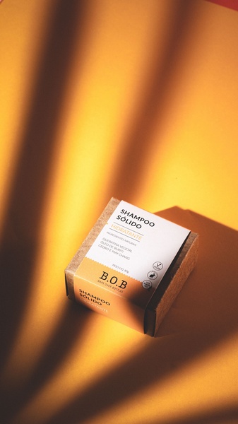 A high-contrast, professional product shot of a solid shampoo bar on a warm, monochromatic background, emphasizing the product's natural ingredients.