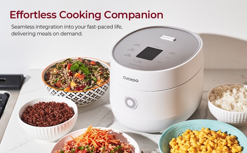 A clean, high-angle product photograph featuring a white rice cooker surrounded by various bowls of ready-to-eat meals, emphasizing convenience.