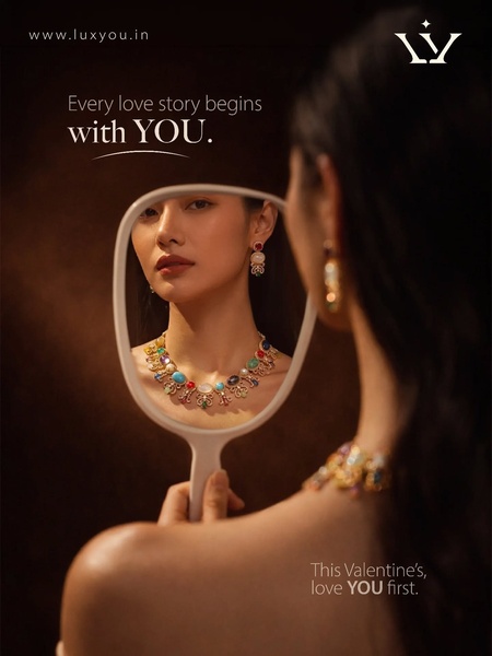 A refined, intimate portrait of a woman looking into a handheld mirror, showcasing an intricate colorful necklace. The ad focuses on self-love and personal style.
