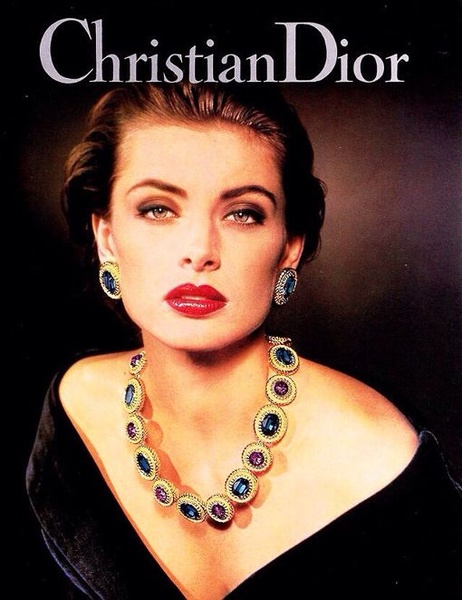 A high-fashion portrait focused on a statement necklace, using bold colors and a classic, high-end studio lighting aesthetic.