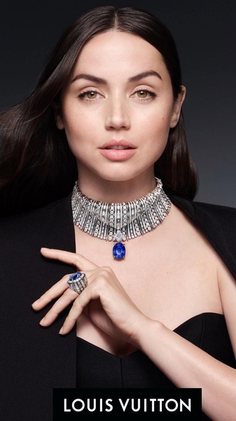 A portrait-style brand creative featuring a high-end necklace and matching ring on a model with a dark, moody background.