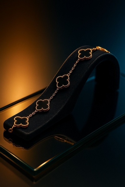 A high-end, studio-lit photograph of a four-leaf clover motif bracelet displayed on a velvet stand, emphasizing luxury and texture.