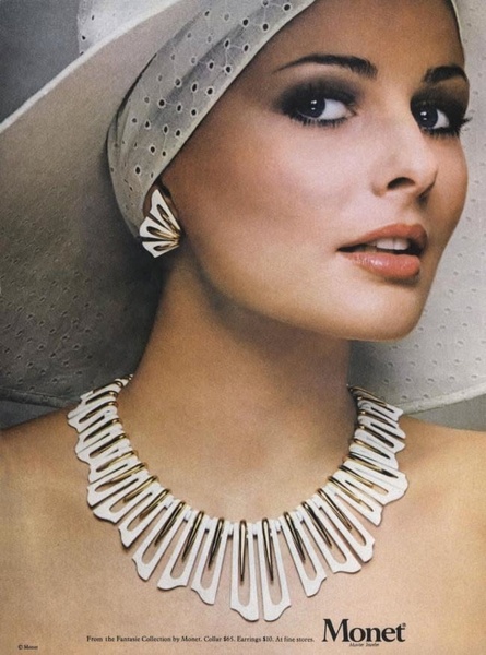 A close-up, high-fashion shot of a model wearing a distinctive white and gold necklace and matching earring, conveying elegance and brand prestige.