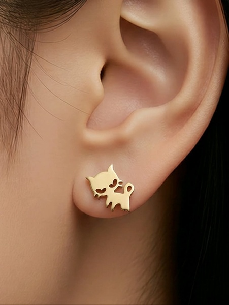 A close-up product hero shot of a minimalist gold cat-shaped earring worn on a model's ear, highlighting delicate design and metal finish.