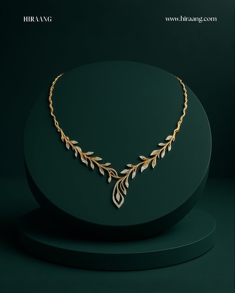 A high-end, minimalist studio photography shot of a delicate gold leaf necklace centered on a dark green pedestal.