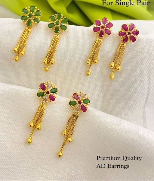 A clean, studio-lit presentation featuring three pairs of gold drop earrings with floral stud designs and varying gemstone colors.