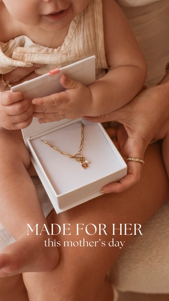 A close-up, high-sentiment photo of a baby's hands opening a jewelry box to reveal a gold chain, focusing on emotional connection and gifting.