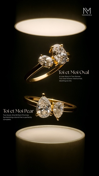 Two elegant rings are suspended under a single, dramatic light source against a stark black background to emphasize their intricate detail and design.