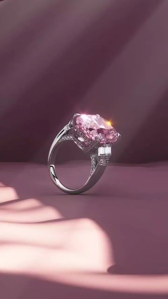 A high-end, close-up shot of a large pink diamond ring resting on a luxurious, draped purple fabric background under dramatic lighting.
