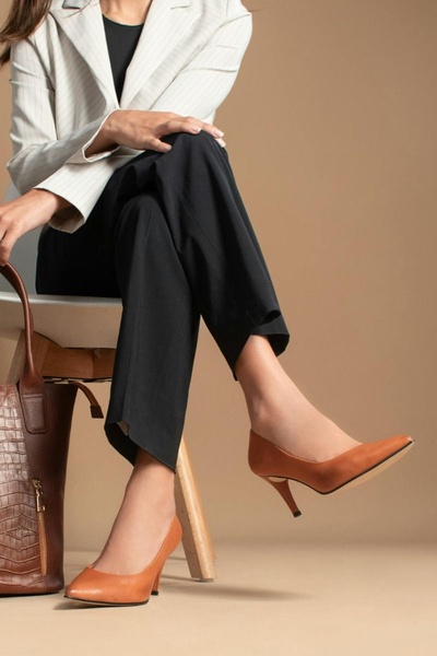 A refined product-centric ad featuring a professional wearing elegant heels, emphasizing clean lines and sophisticated lifestyle branding.