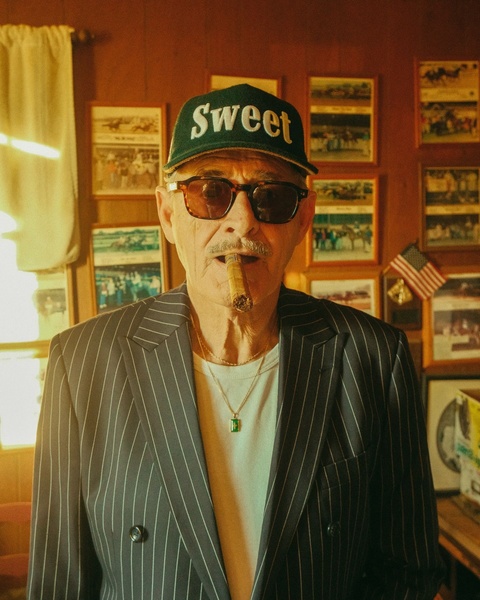A portrait-style ad featuring a man wearing a branded baseball cap, utilizing a warm, nostalgic filter to evoke a distinct lifestyle aesthetic.