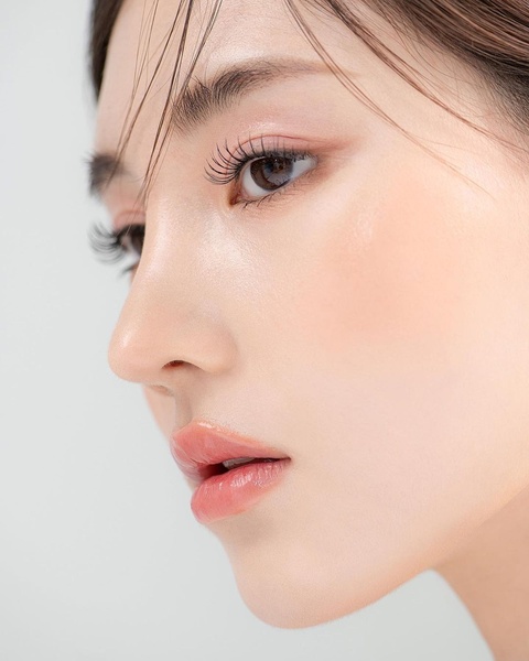 An extreme close-up focusing on a model's facial features and glowing skin to emphasize the quality of a beauty product.