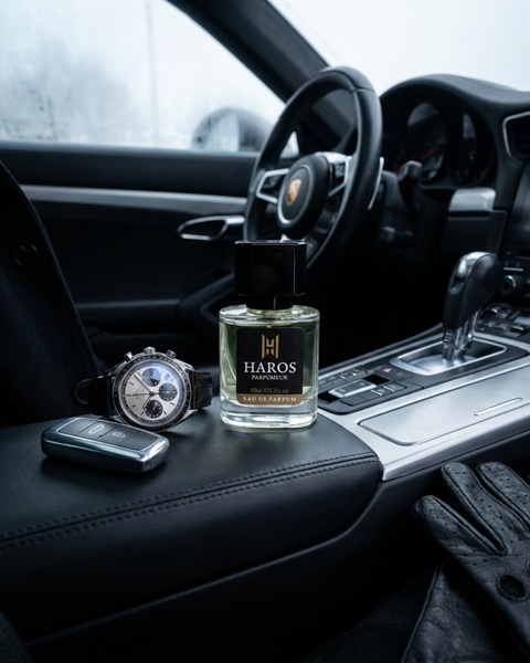 A high-end, clean product shot featuring a perfume bottle placed inside a luxury car, alongside a watch and car key to evoke status.