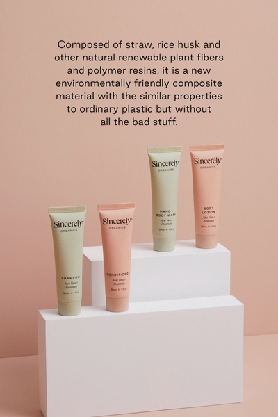 A minimalist studio shot showcasing a sustainable shampoo, conditioner, body wash, and lotion set on geometric pedestals.