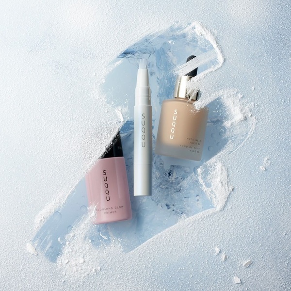 A high-end product hero shot featuring cosmetic bottles placed within a textured, frosted ice-like setting.