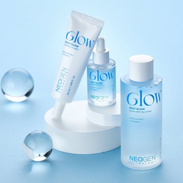 A high-quality studio shot of a skincare cream, serum, and toner, using a cohesive blue color palette and clean, geometric staging.
