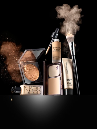 A high-end composition featuring liquid cosmetic foundation, face powder, and a professional makeup brush captured mid-air with powder impact effects.