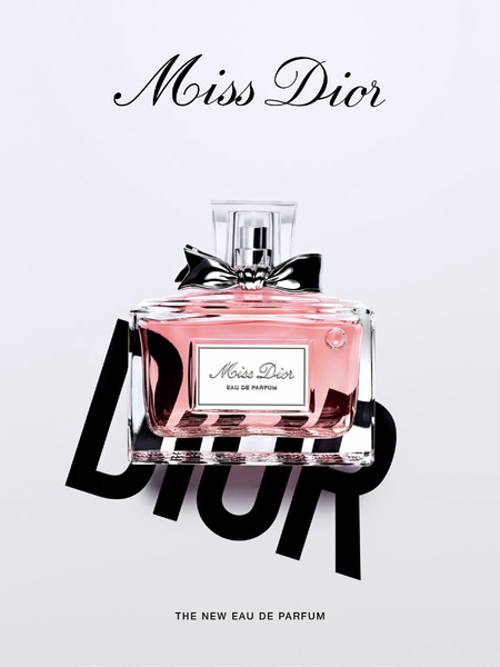 A clean, studio-lit photograph of a perfume bottle featuring a elegant bow, centered over stylized bold typography.