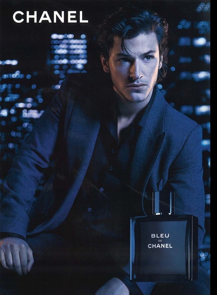 A high-end fragrance ad featuring a male model in a dark, moody city setting to convey sophistication.