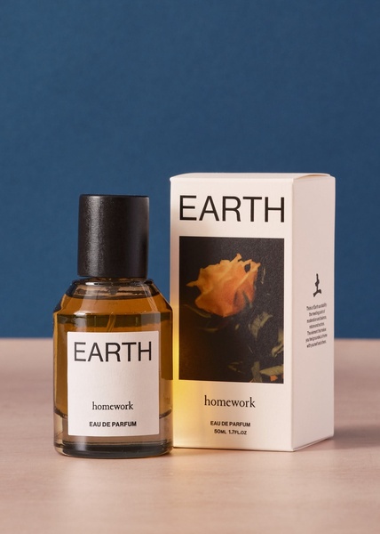 A clean, studio-lit photograph of a perfume bottle and its packaging against a bold blue background, emphasizing natural simplicity.