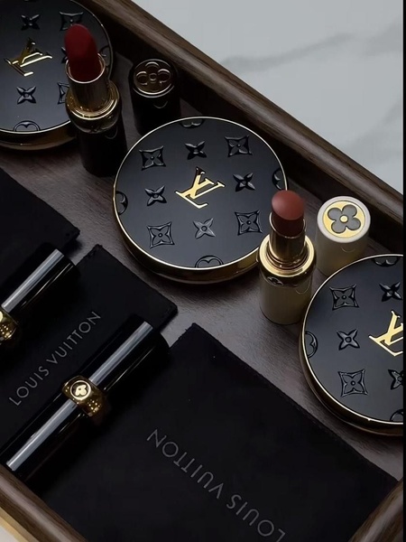 A high-end flatlay composition featuring luxury lipstick cases and compacts arranged on a polished wooden tray, conveying premium quality and sophisticated beauty.
