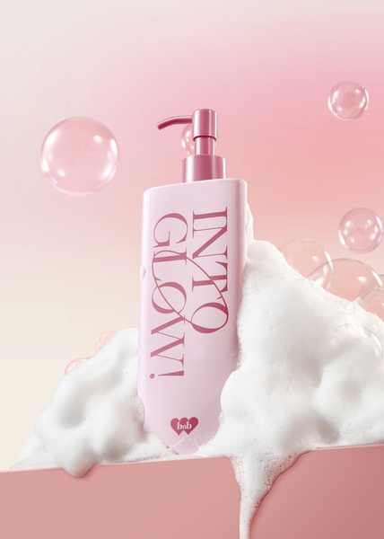 A high-end product hero creative featuring a cleansing foam bottle emerging from dense, soft soap bubbles against a warm, gradient pink background.