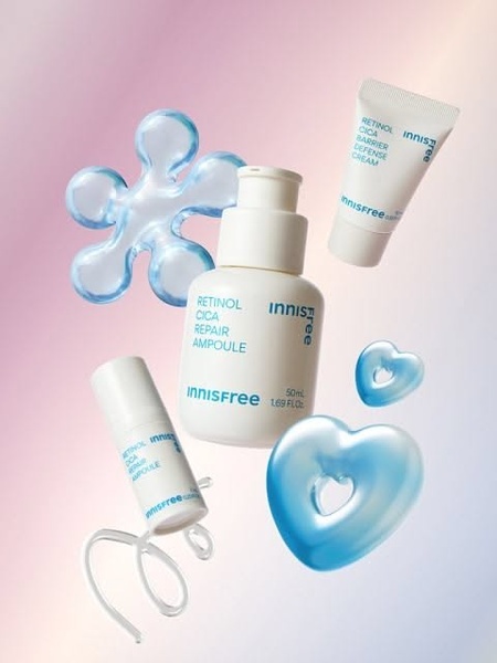 A clean, high-aesthetic product photography composition featuring the Retinol Cica Repair Ampoule alongside abstract blue shapes on a gradient background.