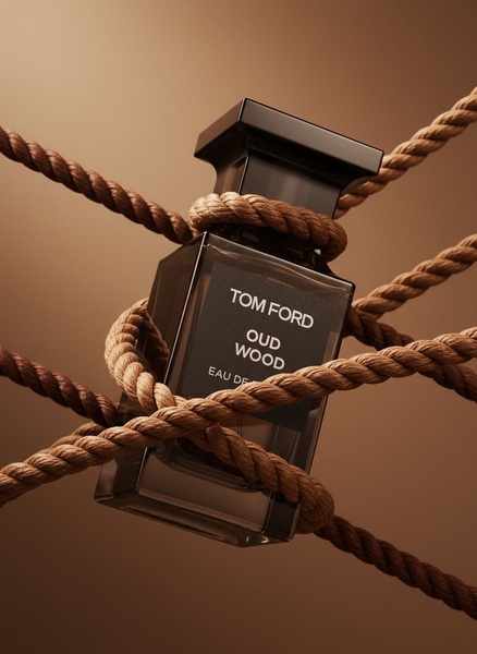 A luxury perfume bottle wrapped in nautical ropes against a soft, monochromatic brown backdrop.