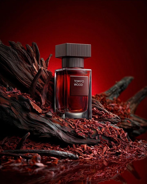 A high-end perfume bottle placed amidst dark, rich wood fragments and deep red lighting for a premium, sensory-focused visual.