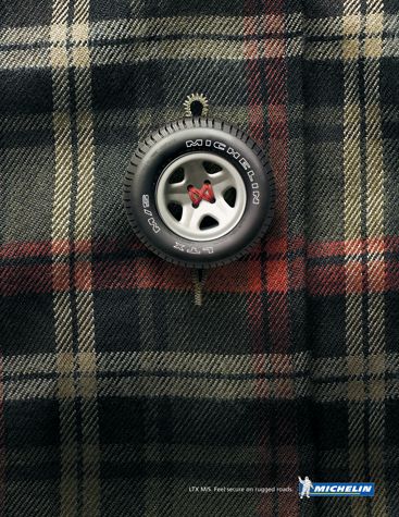 A close-up shot of a tire acting as a button on a plaid shirt, symbolizing strength and security.