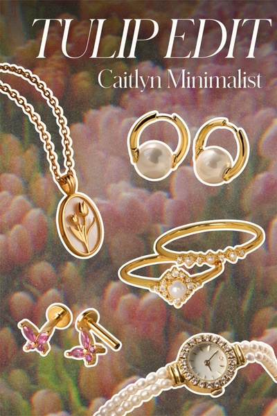 A high-end editorial display of a gold-toned jewelry collection featuring pearl, tulip, and butterfly motifs set against a soft, textured background.