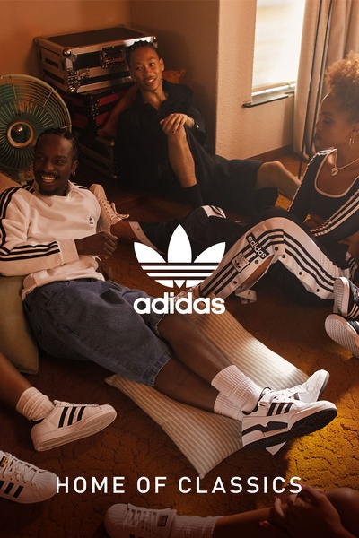 A group of friends relaxing in a warm, dimly lit room, showcasing classic sneakers as part of a casual, authentic lifestyle narrative.