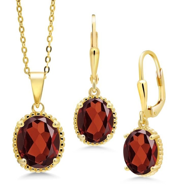 A clean, studio-lit hero shot of a matching garnet pendant necklace and drop earring set on a stark white background.