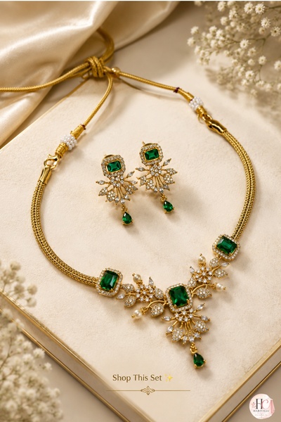 A high-end, studio-lit photograph featuring a gold and emerald jewelry set arranged neatly on a velvet-textured surface.