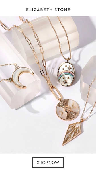 A high-end, clean product flat lay showcasing four distinct celestial-themed gold necklaces on clear acrylic stands against a white background.