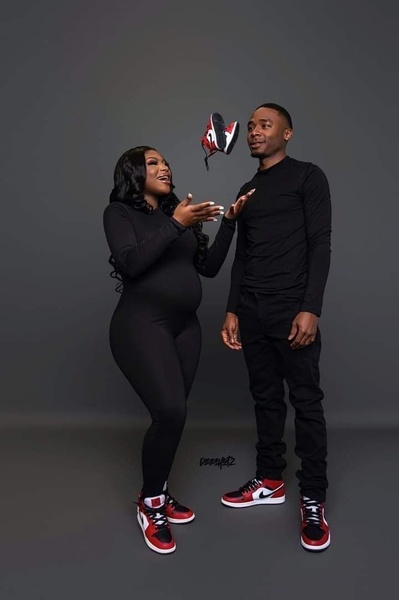 A couple holds baby sneakers in the air, creating a soft, emotional moment that keeps the product as the central focus.