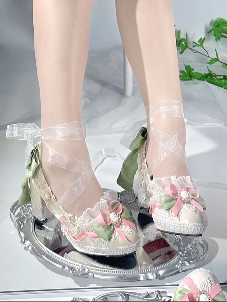 A close-up, high-quality product shot of white ribbon-tied heels with pastel accents, resting on a silver decorative tray.
