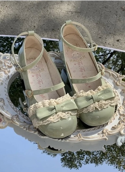 A close-up, high-aesthetic product shot of green Lolita-style Mary Jane shoes placed on a vintage-style mirror.