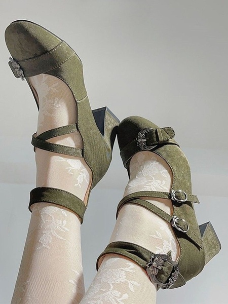 A close-up, bottom-up perspective of platform heels worn with floral hosiery against a neutral background.