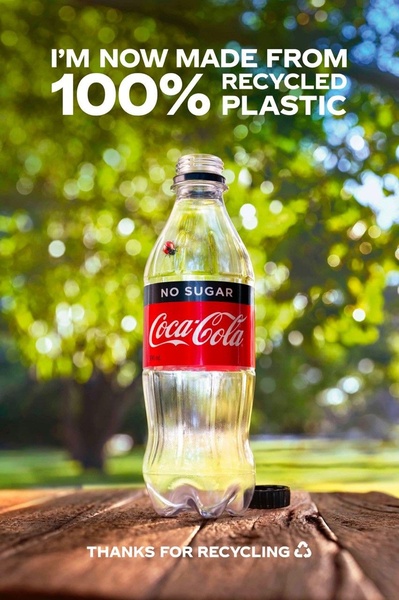 A high-quality product shot of a beverage bottle set against a natural, sun-drenched outdoor background to highlight new sustainable packaging.